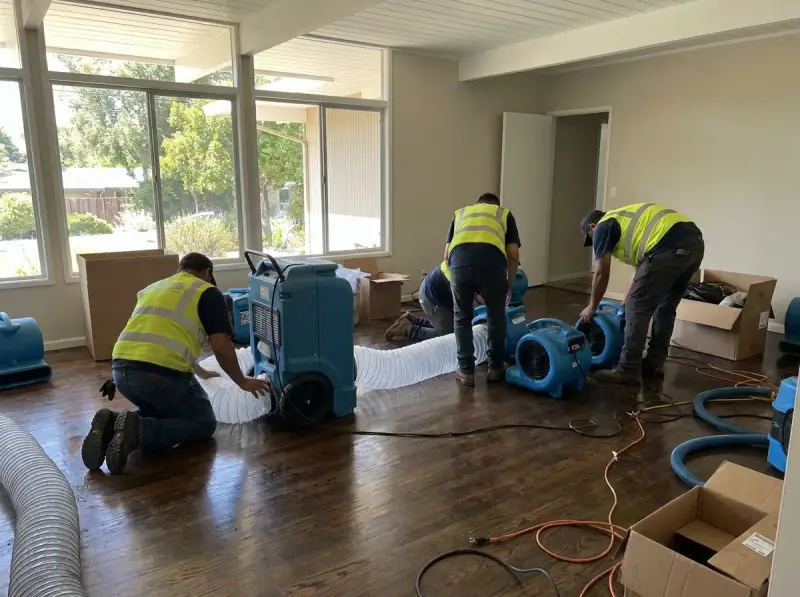 Commercial air movers and an LGR dehumidifier running on a wet floor in Sunnyvale, California