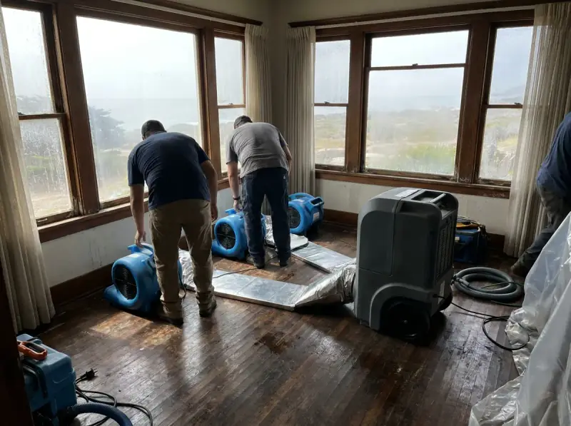 Commercial air movers and an LGR dehumidifier running on a wet floor in Ventura, California